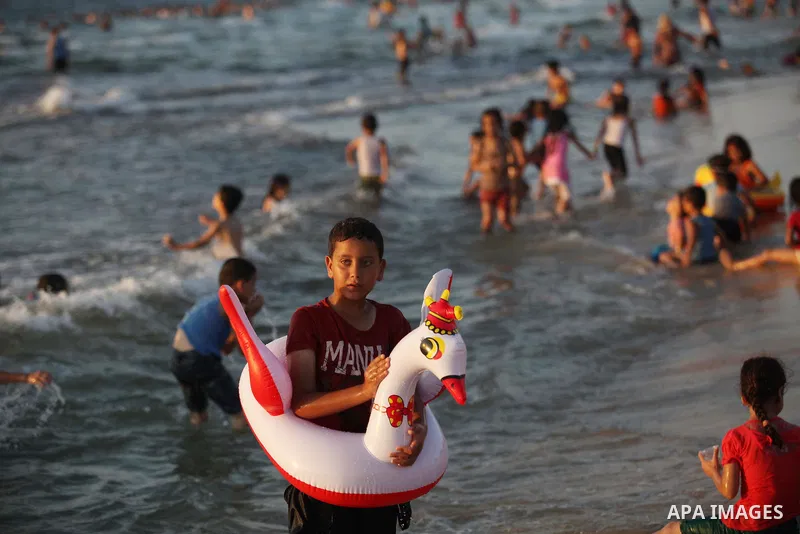 Palestinians swim in the Mediterranean Sea off the coast of Gaza City August 29, 2014, days after a ceasefire was reached. An open-ended ceasefire, mediated by Egypt, took effect on Tuesday evening. It called for an inde...