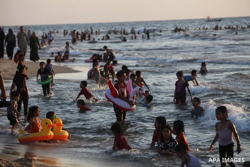 Palestinians swim in the Mediterranean Sea off the coast of Gaza City August 29, 2014, days after a ceasefire was reached. An open-ended ceasefire, mediated by Egypt, took effect on Tuesday evening. It called for an inde...