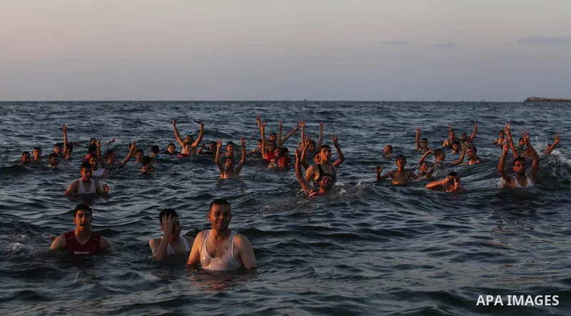 Palestinians swim in the Mediterranean Sea off the coast of Gaza City August 29, 2014, days after a ceasefire was reached. An open-ended ceasefire, mediated by Egypt, took effect on Tuesday evening. It called for an inde...