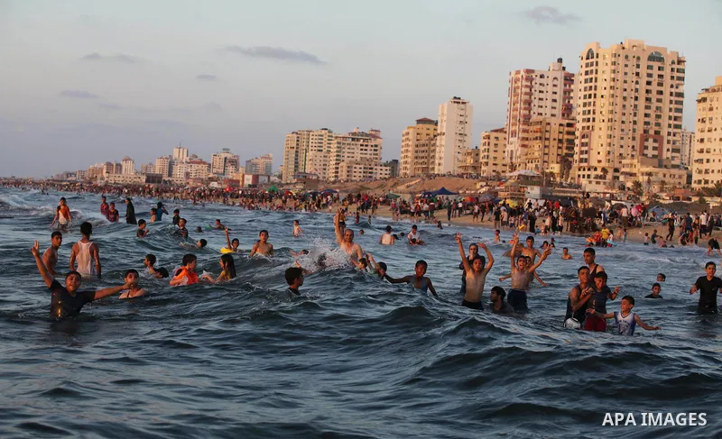 Palestinians swim in the Mediterranean Sea off the coast of Gaza City August 29, 2014, days after a ceasefire was reached. An open-ended ceasefire, mediated by Egypt, took effect on Tuesday evening. It called for an inde...