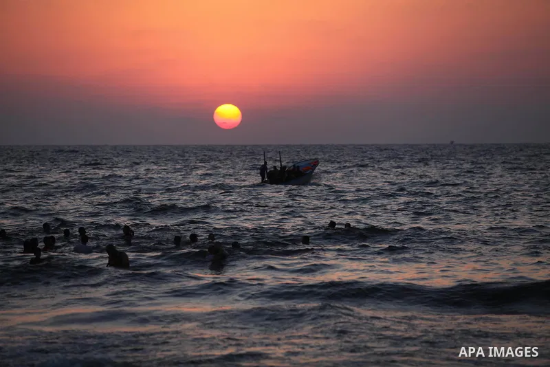 Palestinians swim in the Mediterranean Sea off the coast of Gaza City during sunset August 29, 2014, days after a ceasefire was reached. An open-ended ceasefire, mediated by Egypt, took effect on Tuesday evening. It call...