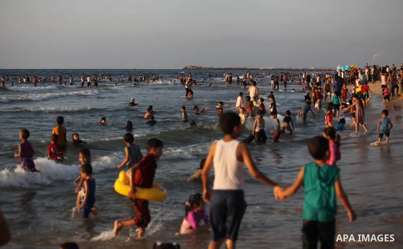 Palestinians swim in the Mediterranean Sea off the coast of Gaza City August 29, 2014, days after a ceasefire was reached. An open-ended ceasefire, mediated by Egypt, took effect on Tuesday evening. It called for an inde...
