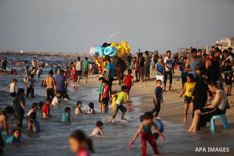 Palestinians swim in the Mediterranean Sea off the coast of Gaza City August 29, 2014, days after a ceasefire was reached. An open-ended ceasefire, mediated by Egypt, took effect on Tuesday evening. It called for an inde...