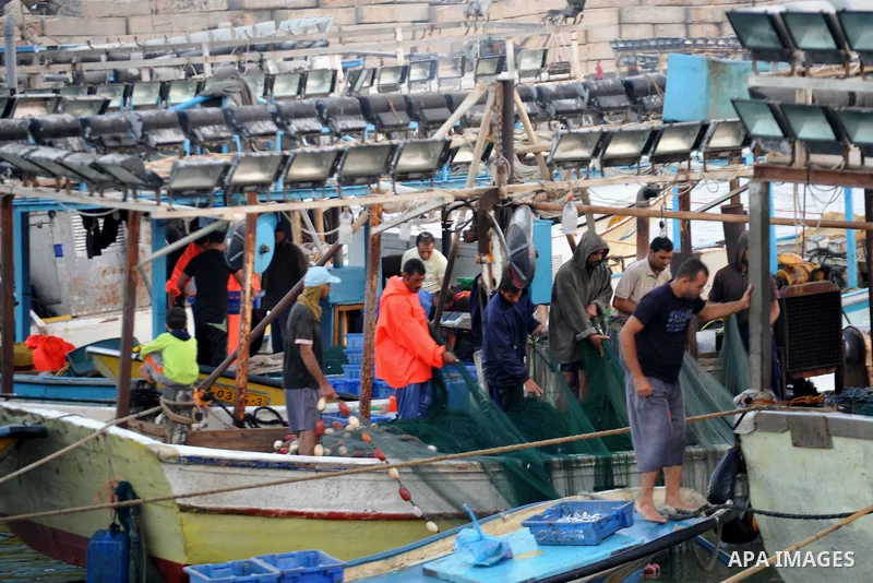 Palestinian fishermen clean their boats at Gaza's seaport in Gaza City early on August 29, 2014. Israel and Hamas accepted an Egyptian proposal for a long-term ceasefire in war-torn Gaza on August 26 in a move to end 50...
