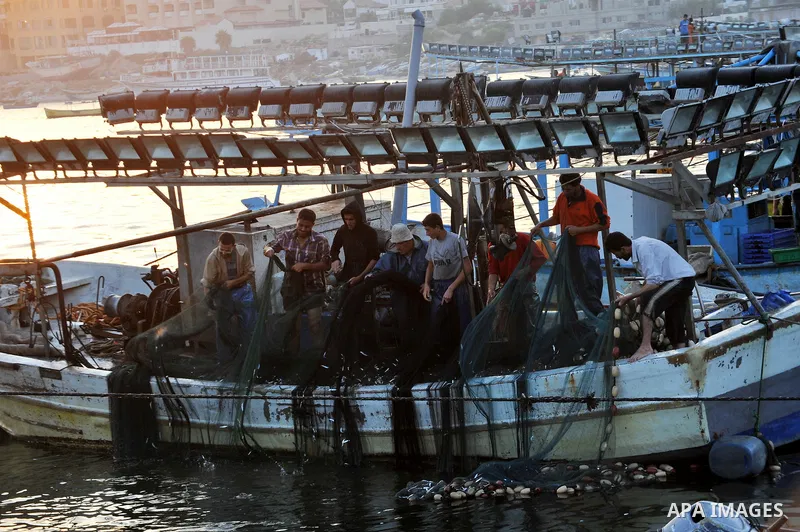 Palestinian fishermen clean their boats at Gaza's seaport in Gaza City early on August 29, 2014. Israel and Hamas accepted an Egyptian proposal for a long-term ceasefire in war-torn Gaza on August 26 in a move to end 50...