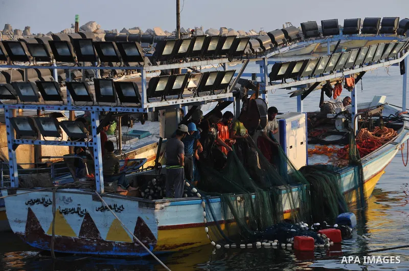 Palestinian fishermen clean their boats at Gaza's seaport in Gaza City early on August 29, 2014. Israel and Hamas accepted an Egyptian proposal for a long-term ceasefire in war-torn Gaza on August 26 in a move to end 50...