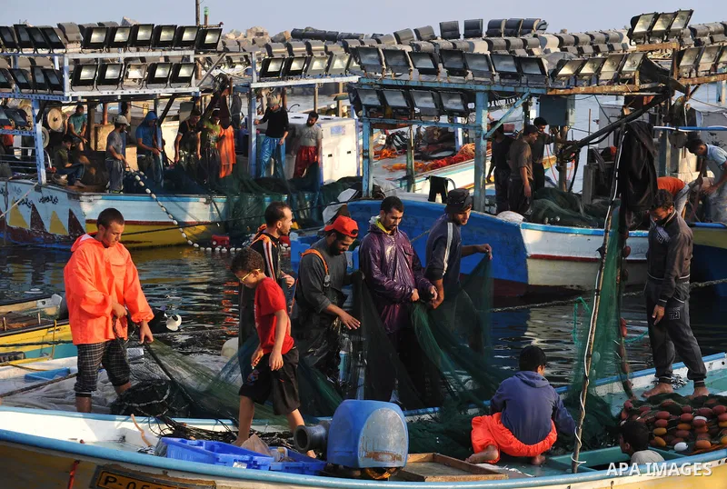 Palestinian fishermen clean their boats at Gaza's seaport in Gaza City early on August 29, 2014. Israel and Hamas accepted an Egyptian proposal for a long-term ceasefire in war-torn Gaza on August 26 in a move to end 50...