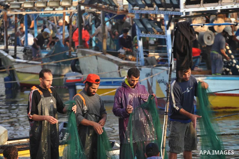 Palestinian fishermen clean their boats at Gaza's seaport in Gaza City early on August 29, 2014. Israel and Hamas accepted an Egyptian proposal for a long-term ceasefire in war-torn Gaza on August 26 in a move to end 50...