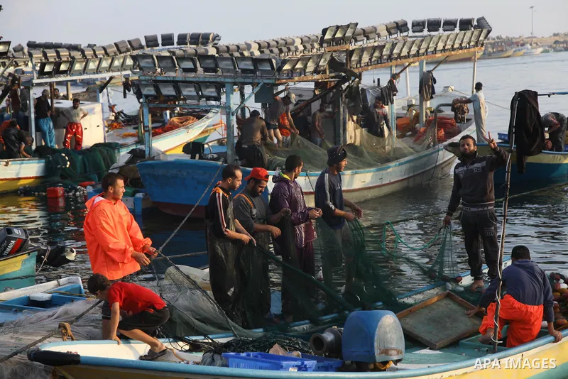 Palestinian fishermen clean their boats at Gaza's seaport in Gaza City early on August 29, 2014. Israel and Hamas accepted an Egyptian proposal for a long-term ceasefire in war-torn Gaza on August 26 in a move to end 50...