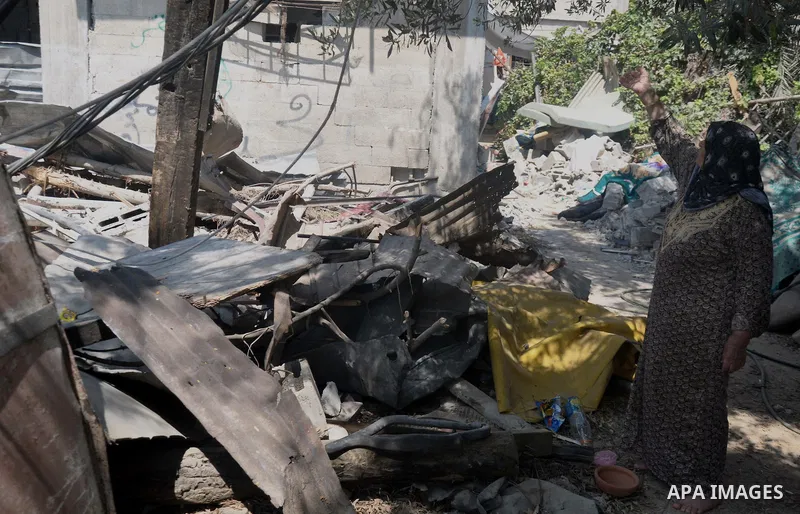 A Palestinian woman stand past her house which witnesses said was destroyed during the Israeli offensive in Shejaiya neighborhood after a ceasefire was declared, in Gaza city on August 30, 2014. An open-ended ceasefire,...