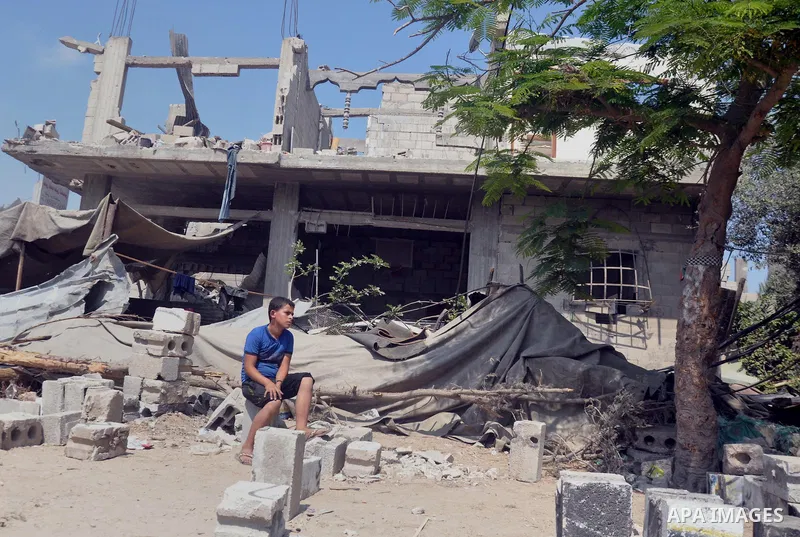 A Palestinian boy sits on the rubble of his house which witnesses said was destroyed during the Israeli offensive in Shejaiya neighborhood after a ceasefire was declared, in Gaza city on August 30, 2014. An open-ended ce...