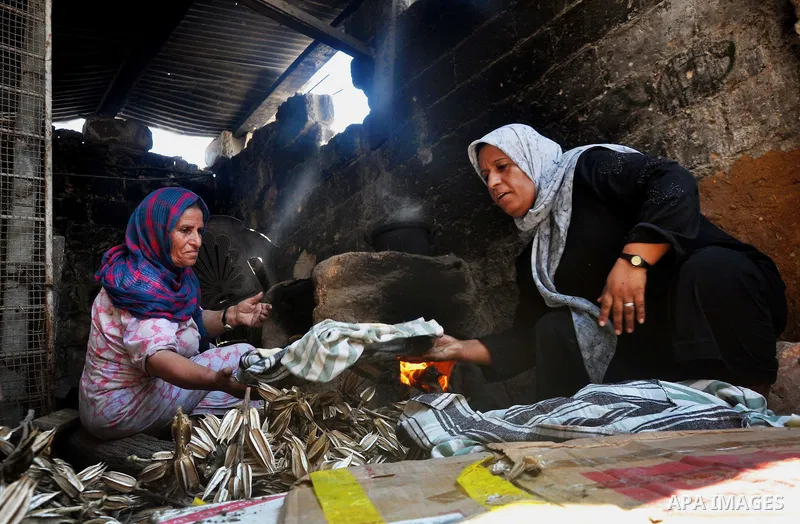 Palestinian women bake bread on the rubble of their house which witnesses said was destroyed during the Israeli offensive in Shejaiya neighborhood after a ceasefire was declared, in Gaza city on August 30, 2014. An open-...