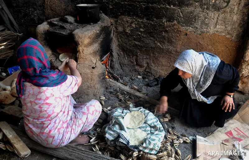 Palestinian women bake bread on the rubble of their house which witnesses said was destroyed during the Israeli offensive in Shejaiya neighborhood after a ceasefire was declared, in Gaza city on August 30, 2014. An open-...