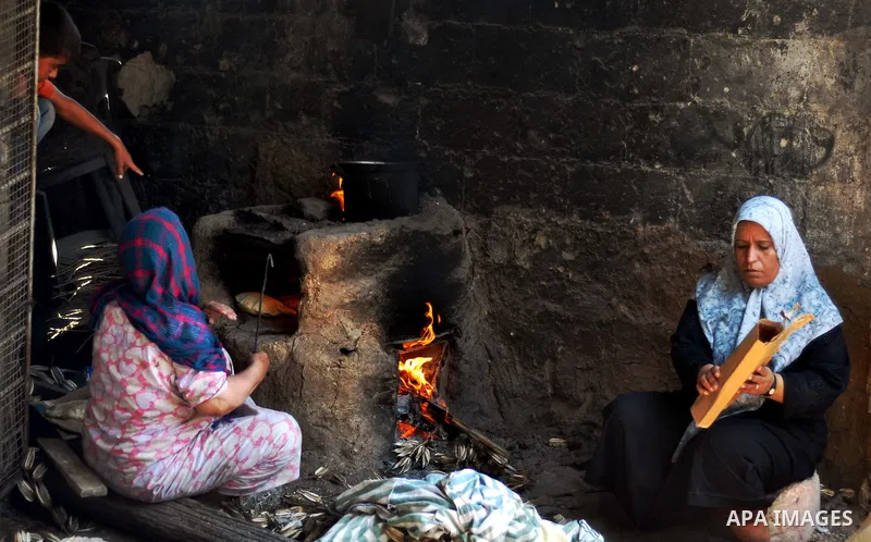 Palestinian women bake bread on the rubble of their house which witnesses said was destroyed during the Israeli offensive in Shejaiya neighborhood after a ceasefire was declared, in Gaza city on August 30, 2014. An open-...