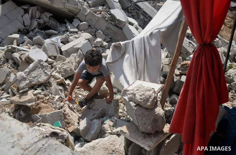 A Palestinian boy collects his belongings from under the rubble of his house which witnesses said was destroyed during the Israeli offensive in Shejaiya neighborhood after a ceasefire was declared, in Gaza city on August...