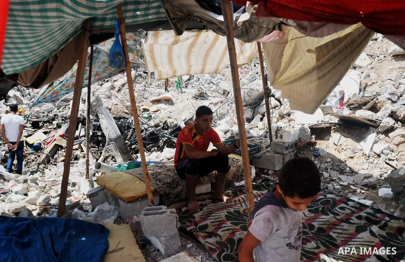 Palestinians sit at a tent on the rubble of their house which witnesses said was destroyed during the Israeli offensive in Shejaiya neighborhood after a ceasefire was declared, in Gaza city on August 30, 2014. An open-en...