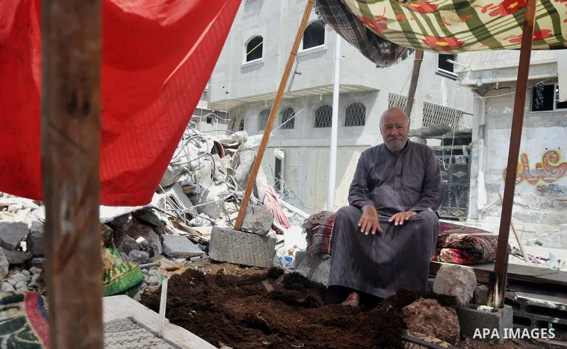 A Palestinian man sits at a tent on a the rubble of his house which witnesses said was destroyed during the Israeli offensive in Shejaiya neighborhood after a ceasefire was declared, in Gaza city on August 30, 2014. An o...