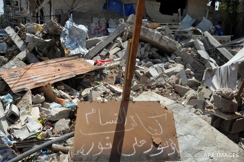 Palestinians sit at a tent on a the rubble of their house which witnesses said was destroyed during the Israeli offensive in Shejaiya neighborhood after a ceasefire was declared, in Gaza city on August 30, 2014. An open-...