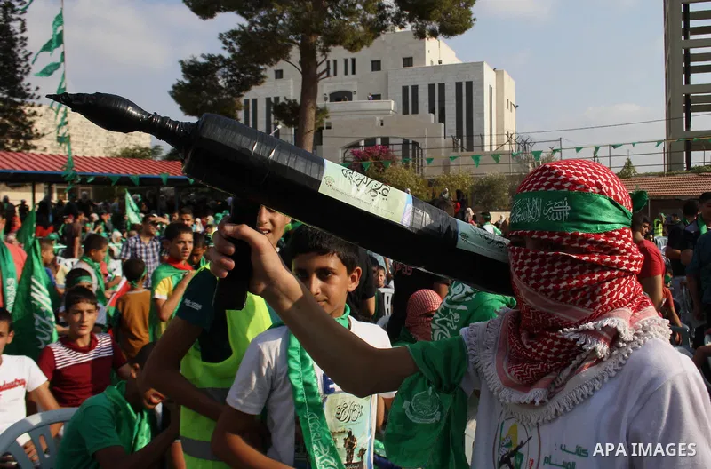 A masked Palestinian boy holds a mock rocket during a rally showing their support and solidarity with Hamas in the West Bank city of Tulkarem, 30 August 2014. An indefinite ceasefire to end seven weeks of fighting betwee...