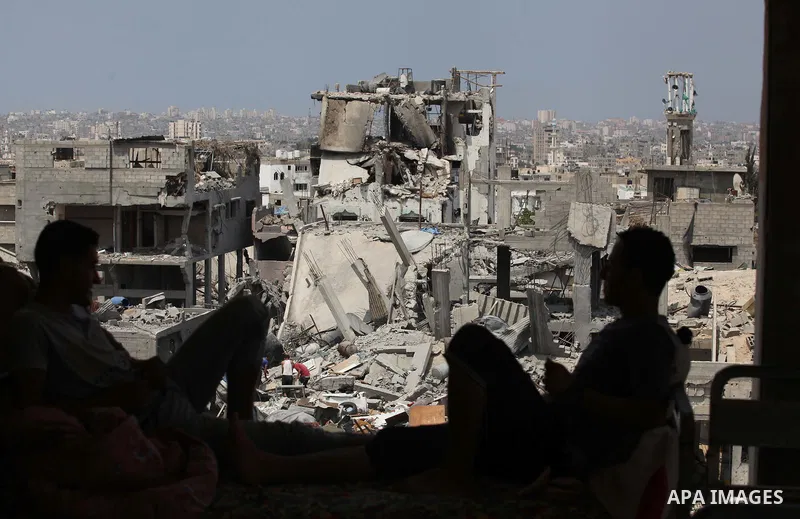 Palestinians sit on a sofa at their house which destroyed during fighting between Hamas militants and Israel in the Al-Shaaf neighbourhood, in Gaza City, on August 31, 2014. An indefinite ceasefire to end seven weeks of...