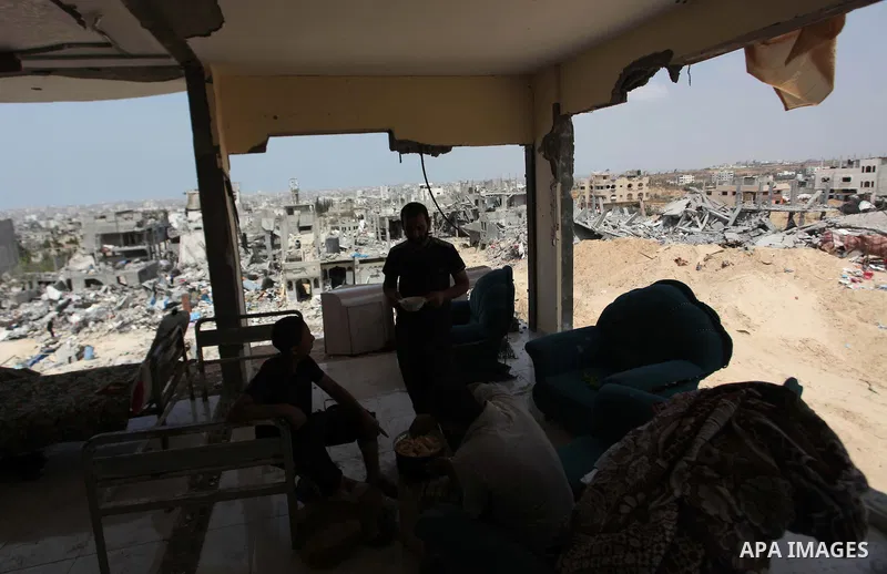 Palestinians sit on a sofa at their house which destroyed during fighting between Hamas militants and Israel in the Al-Shaaf neighbourhood, in Gaza City, on August 31, 2014. An indefinite ceasefire to end seven weeks of...