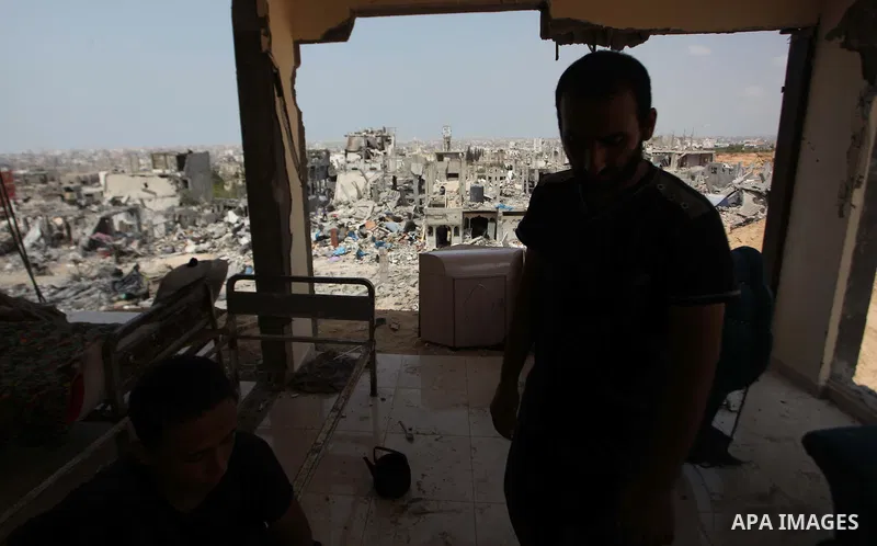 Palestinians sit on a sofa at their house which destroyed during fighting between Hamas militants and Israel in the Al-Shaaf neighbourhood, in Gaza City, on August 31, 2014. An indefinite ceasefire to end seven weeks of...