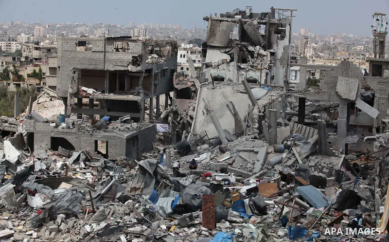 Palestinians walk on the rubble of buildings destroyed during fighting between Hamas militants and Israel in the Al-Shaaf neighbourhood, in Gaza City, on August 31, 2014. An indefinite ceasefire to end seven weeks of fig...