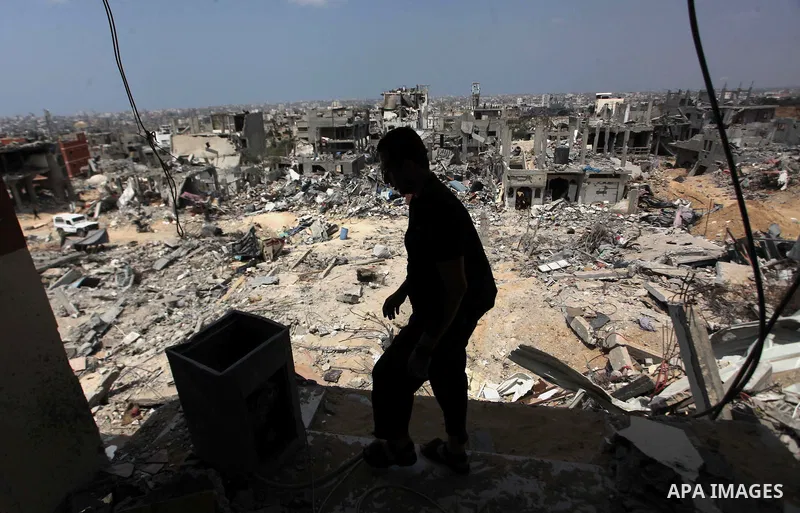 A Palestinian man walks past buildings destroyed during fighting between Hamas militants and Israel in the Al-Shaaf neighbourhood, in Gaza City, on August 31, 2014. An indefinite ceasefire to end seven weeks of fighting...