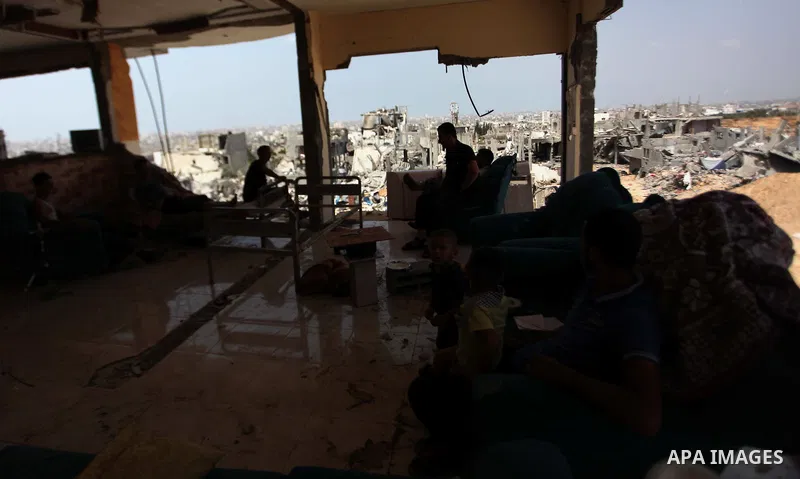 Palestinians sit on a sofa at their house which destroyed during fighting between Hamas militants and Israel in the Al-Shaaf neighbourhood, in Gaza City, on August 31, 2014. An indefinite ceasefire to end seven weeks of...