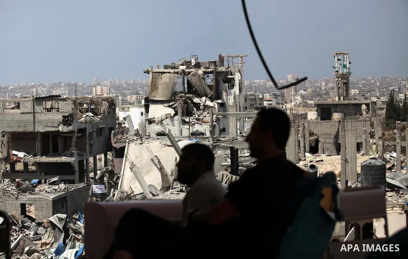 Palestinians sit on a sofa at their house which destroyed during fighting between Hamas militants and Israel in the Al-Shaaf neighbourhood, in Gaza City, on August 31, 2014. An indefinite ceasefire to end seven weeks of...