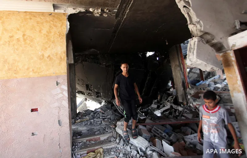 Palestinians walk on the rubble of buildings destroyed during fighting between Hamas militants and Israel in the Al-Shaaf neighbourhood, in Gaza City, on August 31, 2014. An indefinite ceasefire to end seven weeks of fig...