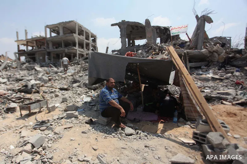 Palestinians set under a tent on the remains of their house which destroyed during fighting between Hamas militants and Israel in the Al-Shaaf neighbourhood, in Gaza City, on August 31, 2014. An indefinite ceasefire to e...