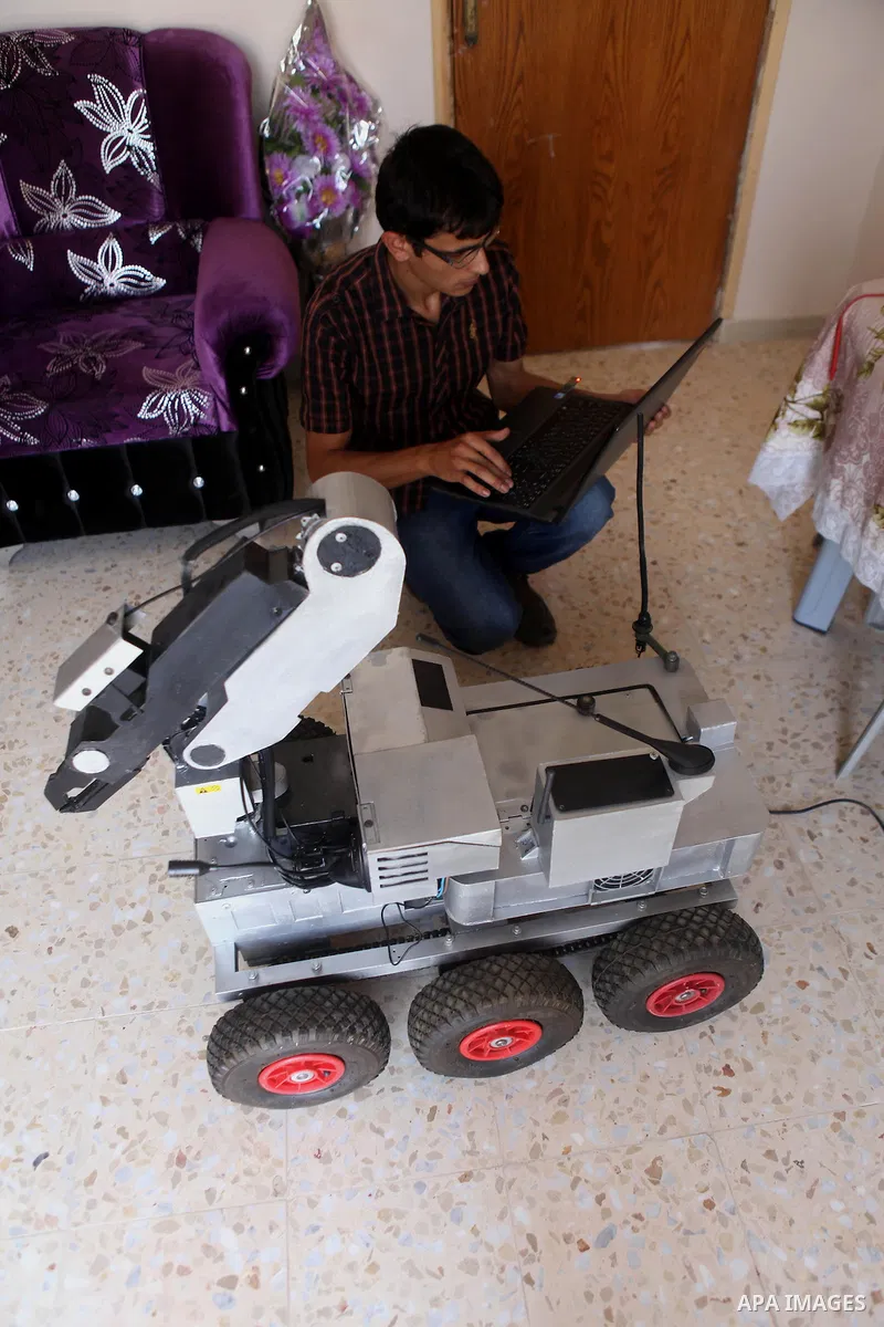 Khalil Awawdeh, a Palestinian inventor who works at his room in the West Bank city of Hebron on August 31, 2014. The 22-year-old man invents explosives detection device and he uses a cartoon to makes military tanks. Phot...