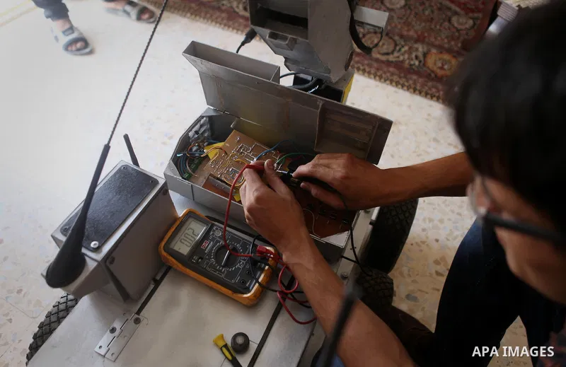 Khalil Awawdeh, a Palestinian inventor who works at his room in the West Bank city of Hebron on August 31, 2014. The 22-year-old man invents explosives detection device and he uses a cartoon to makes military tanks. Phot...