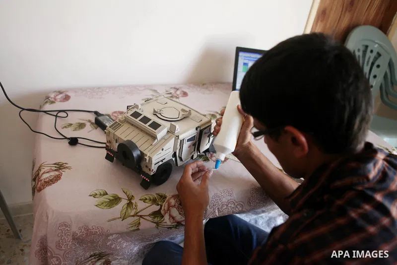 Khalil Awawdeh, a Palestinian inventor who works at his room in the West Bank city of Hebron on August 31, 2014. The 22-year-old man invents explosives detection device and he uses a cartoon to makes military tanks. Phot...
