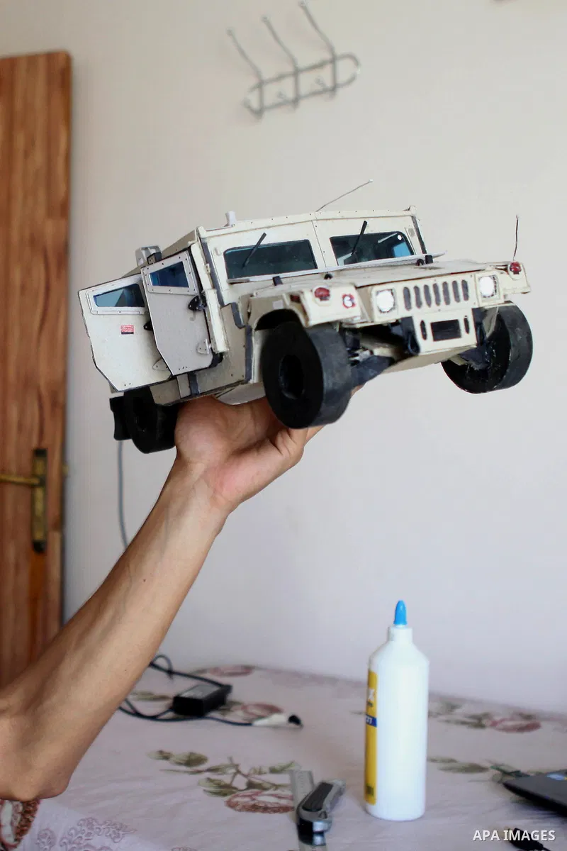 Khalil Awawdeh, a Palestinian inventor displays a military tank that he makes it by a cartoon in the West Bank city of Hebron on August 31, 2014. The 22-year-old man invents explosives detection device and he uses a cart...