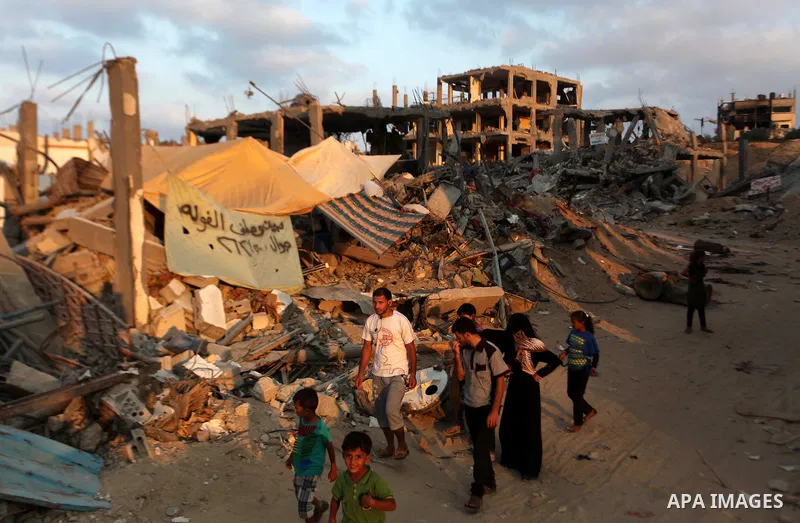 Palestinians walk past destroyed houses after returning home in the Tufah neighbourhood in eastern Gaza City on August 31, 2014. Calm returned to the coastal enclave in a August 26 ceasefire, and Gazans were gradually st...