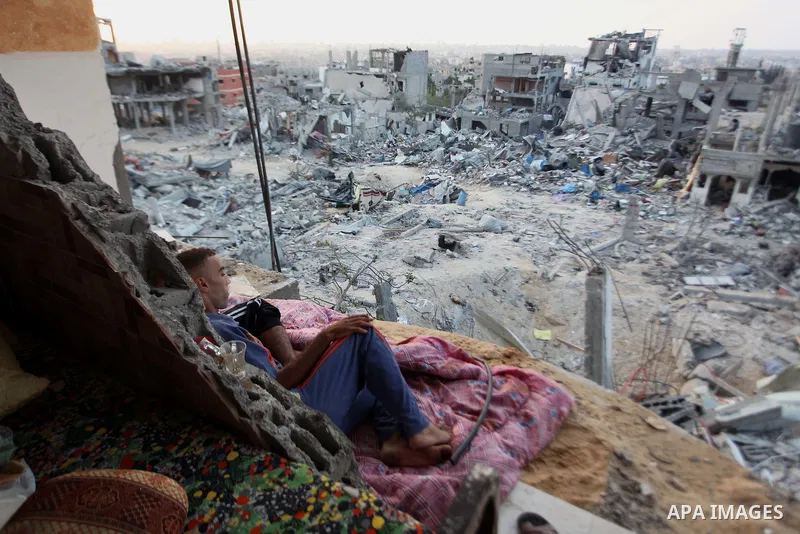 A Palestinian man lies down among a destroyed house after returning home in the Tufah neighbourhood in eastern Gaza City on August 31, 2014. Calm returned to the coastal enclave in a August 26 ceasefire, and Gazans were...