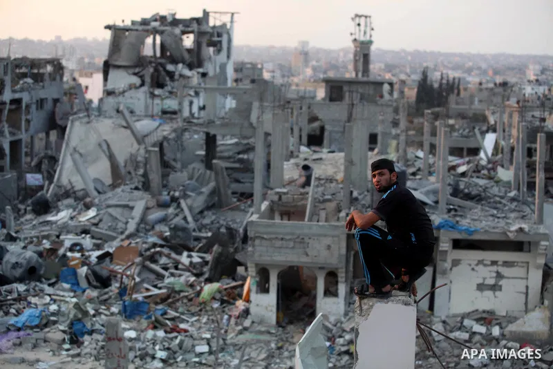 A Palestinian man sits on the rubble of destroyed houses after returning home in the Tufah neighbourhood in eastern Gaza City on August 31, 2014. Calm returned to the coastal enclave in a August 26 ceasefire, and Gazans...