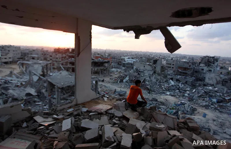 A Palestinian man sits inside his destroyed house after returning home in the Tufah neighbourhood in eastern Gaza City on August 31, 2014. Calm returned to the coastal enclave in a August 26 ceasefire, and Gazans were gr...