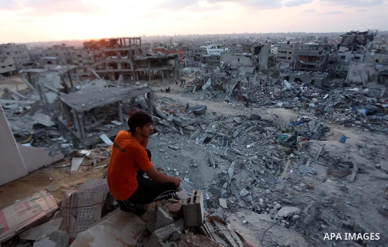 A Palestinian man sits on the rubble of his destroyed house after returning home in the Tufah neighbourhood in eastern Gaza City on August 31, 2014. Calm returned to the coastal enclave in a August 26 ceasefire, and Gaza...