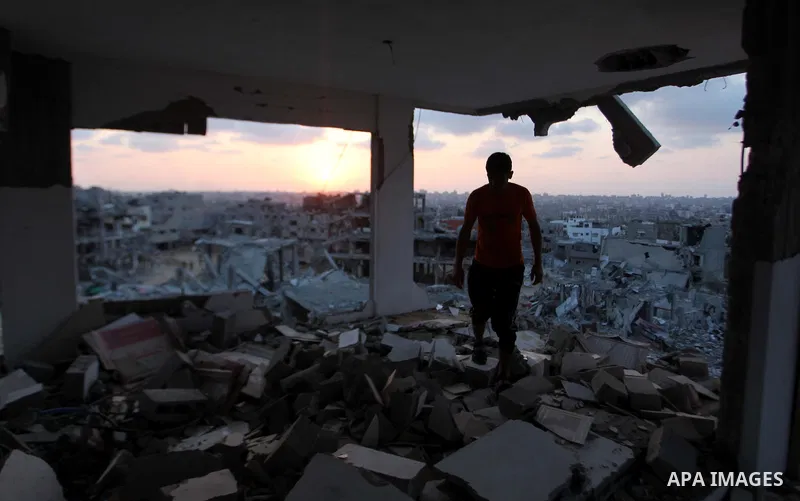 A Palestinian man sits inside his destroyed house after returning home in the Tufah neighbourhood in eastern Gaza City on August 31, 2014. Calm returned to the coastal enclave in a August 26 ceasefire, and Gazans were gr...