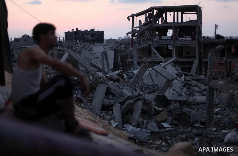 A Palestinian man sits on the rubble of his destroyed house after returning home in the Tufah neighbourhood in eastern Gaza City on August 31, 2014. Calm returned to the coastal enclave in a August 26 ceasefire, and Gaza...