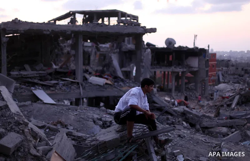 A Palestinian man sits on the rubble of his destroyed house after returning home in the Tufah neighbourhood in eastern Gaza City on August 31, 2014. Calm returned to the coastal enclave in a August 26 ceasefire, and Gaza...
