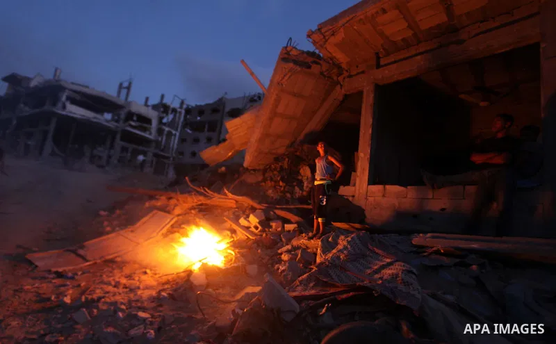 Palestinians walk past a destroyed house after returning home in the Tufah neighbourhood in eastern Gaza City on August 31, 2014. Calm returned to the coastal enclave in a August 26 ceasefire, and Gazans were gradually s...