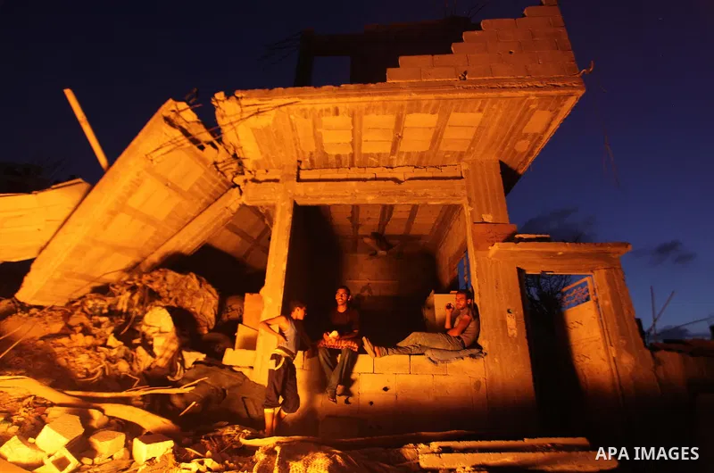 Palestinians sit on the rubble of their destroyed house after returning home in the Tufah neighbourhood in eastern Gaza City on August 31, 2014. Calm returned to the coastal enclave in a August 26 ceasefire, and Gazans w...