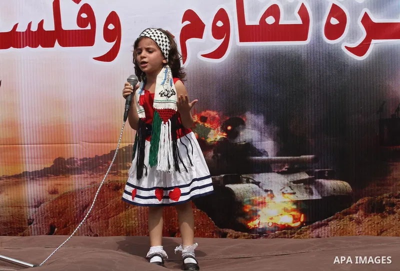 A Palestinian girl takes part in a protest demanding the release of his relative prisoner held in Israeli jails, in front of the Red Cross office in Gaza City, on Sep. 01, 2014. Photo by Mohammed Asad