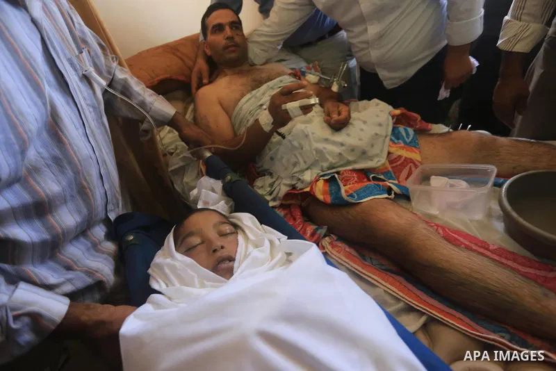 The father of Ziad El-refi, lies on the bed as he mourns during his funeral, at Al-shifa hospital, in Gaza city, on Sep. 01, 2014. El-refi dead on Monday, affected by from serious injury in an Israeli air strike before a...