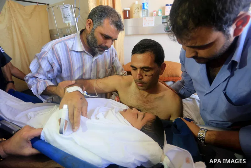 The father of Ziad El-refi, lies on the bed as he mourns during his funeral, at Al-shifa hospital, in Gaza city, on Sep. 01, 2014. El-refi dead on Monday, affected by from serious injury in an Israeli air strike before a...