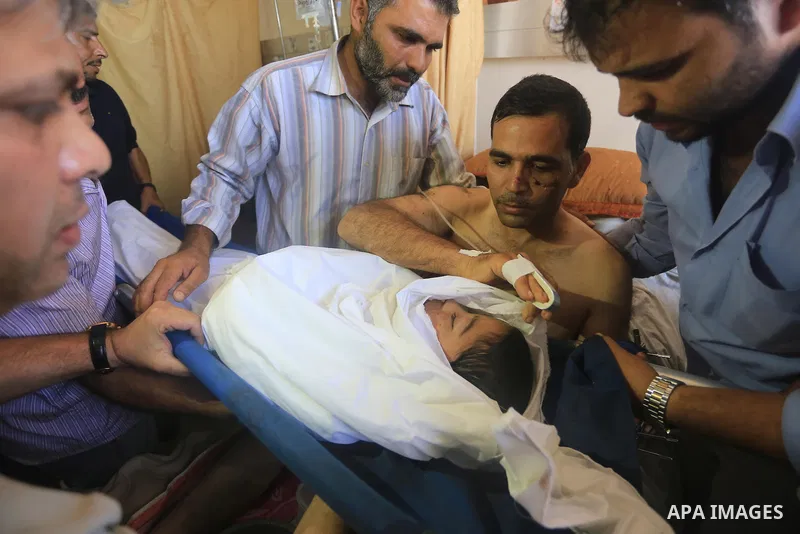 The father of Ziad El-refi, lies on the bed as he mourns during his funeral, at Al-shifa hospital, in Gaza city, on Sep. 01, 2014. El-refi dead on Monday, affected by from serious injury in an Israeli air strike before a...